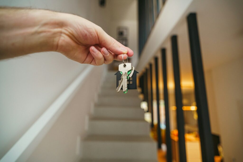 Main tenant un trousseau de clés dans l’entrée d’un logement