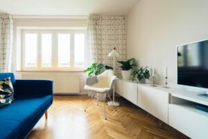 Séjour lumineux avec canapé bleu et parquet