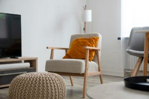 Séjour meublé avec fauteuil, coussin et pouf